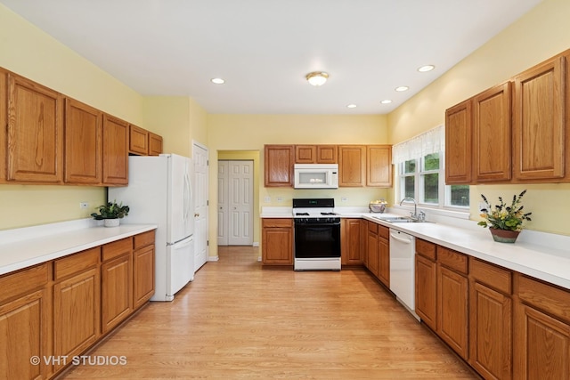 17083 W Tiger Tail Ct, Gurnee, IL 60031 - kitchen with white appliances, a sink, light wood-style floors, brown cabinetry, and light countertops