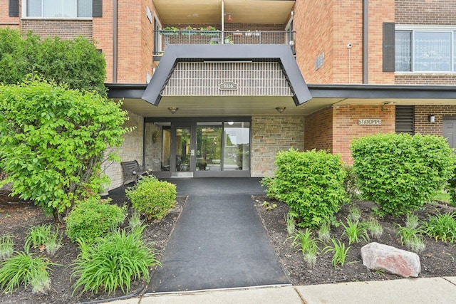 1116 S New Wilke Rd Unit 408, Arlington Heights, IL 60005 - view of exterior entry featuring a balcony, french doors, and brick siding