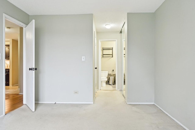 1116 S New Wilke Rd Unit 408, Arlington Heights, IL 60005 - unfurnished bedroom featuring light carpet, baseboards, and connected bathroom