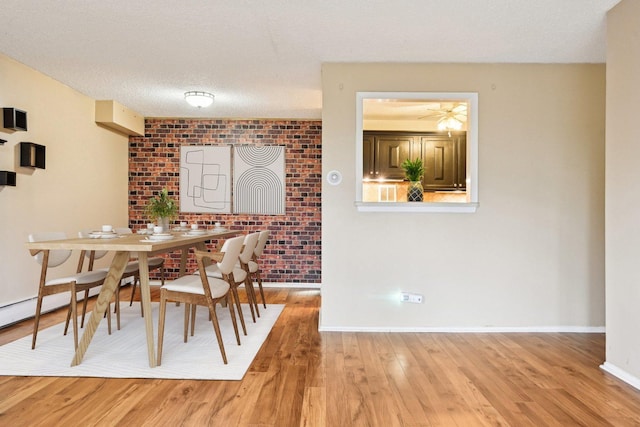 1116 S New Wilke Rd Unit 408, Arlington Heights, IL 60005 - dining room featuring light wood-style flooring, baseboards, brick wall, and a textured ceiling