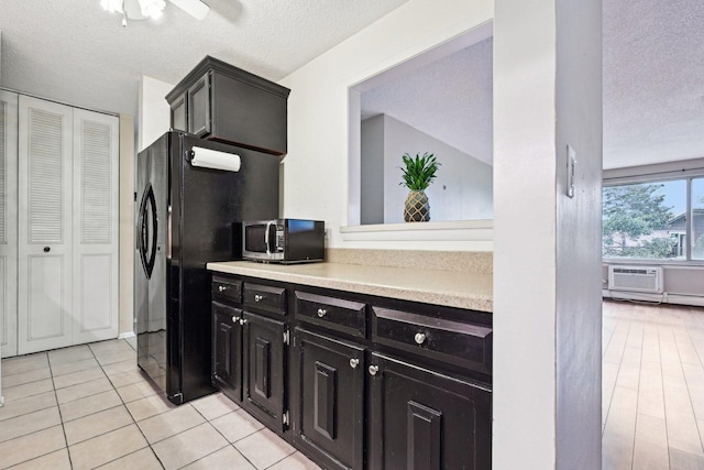 1116 S New Wilke Rd Unit 408, Arlington Heights, IL 60005 - kitchen featuring stainless steel microwave, a textured ceiling, light countertops, dark cabinets, and freestanding refrigerator