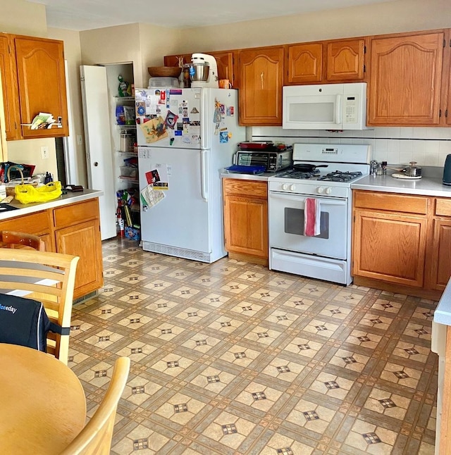 1300 Edington Ln, Mundelein, IL 60060 - kitchen with white appliances, light countertops, brown cabinetry, and light flooring