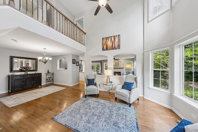 6173 Dixon Dr, Lisle, IL 60532 - living area featuring ceiling fan, a towering ceiling, wood finished floors, arched walkways, and a chandelier
