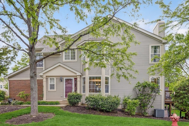 6173 Dixon Dr, Lisle, IL 60532 - view of front of house with a front lawn, a chimney, and central AC unit