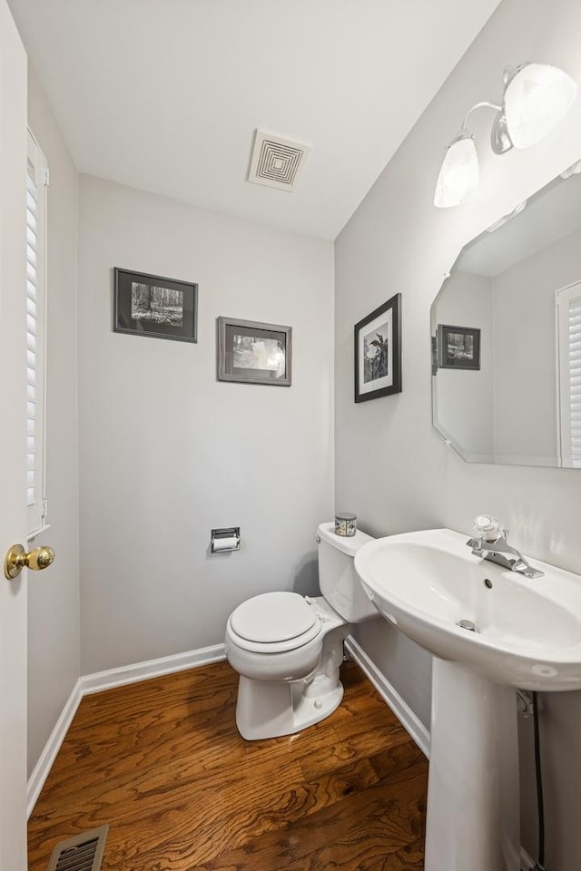 6173 Dixon Dr, Lisle, IL 60532 - half bathroom featuring toilet, wood finished floors, baseboards, and healthy amount of natural light