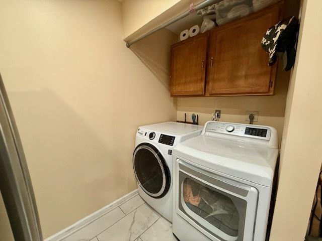 431 Edward St, Sycamore, IL 60178 - laundry area with independent washer and dryer, cabinet space, baseboards, and light marble finish flooring