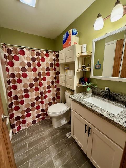 431 Edward St, Sycamore, IL 60178 - bathroom with toilet, vanity, a shower with shower curtain, and wood finish floors