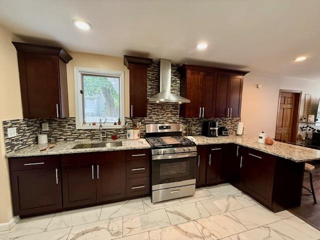 431 Edward St, Sycamore, IL 60178 - kitchen featuring stainless steel gas range, a sink, wall chimney exhaust hood, light marble finish flooring, and a peninsula