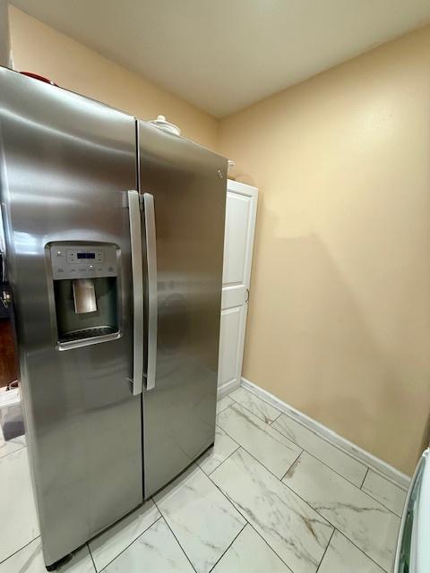 431 Edward St, Sycamore, IL 60178 - kitchen featuring stainless steel refrigerator with ice dispenser, light marble finish flooring, and baseboards
