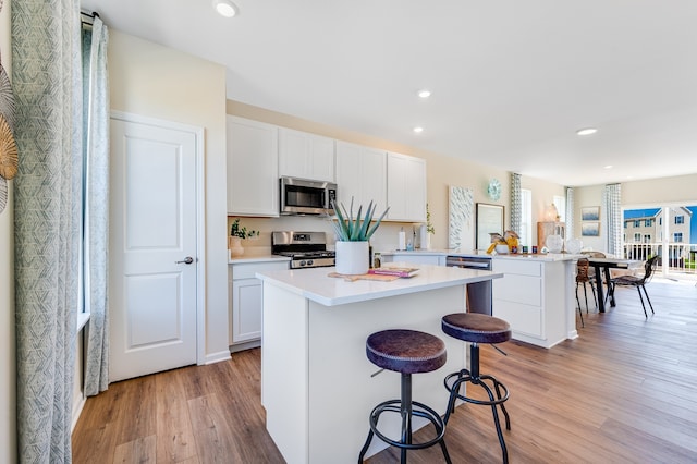 2262 Stonegate Rd, Algonquin, IL 60102 - kitchen featuring stainless steel appliances, a peninsula, a kitchen island, light wood-type flooring, and recessed lighting