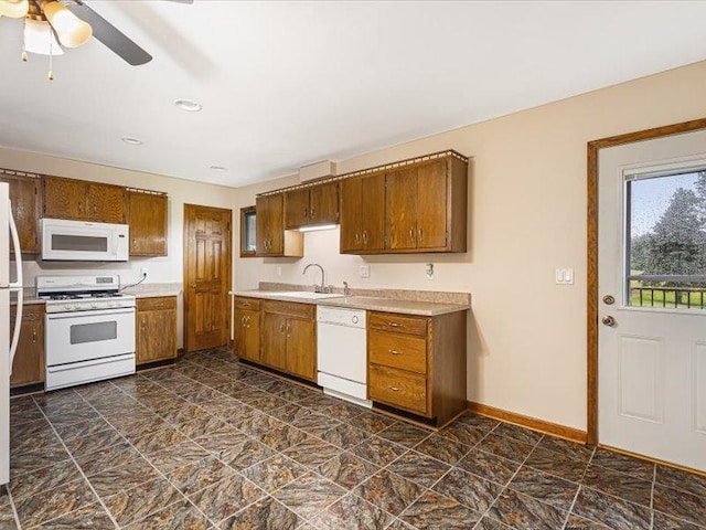4560 Centerville Rd, Rockford, IL 61102 - kitchen with white appliances, a sink, light countertops, brown cabinetry, and a ceiling fan