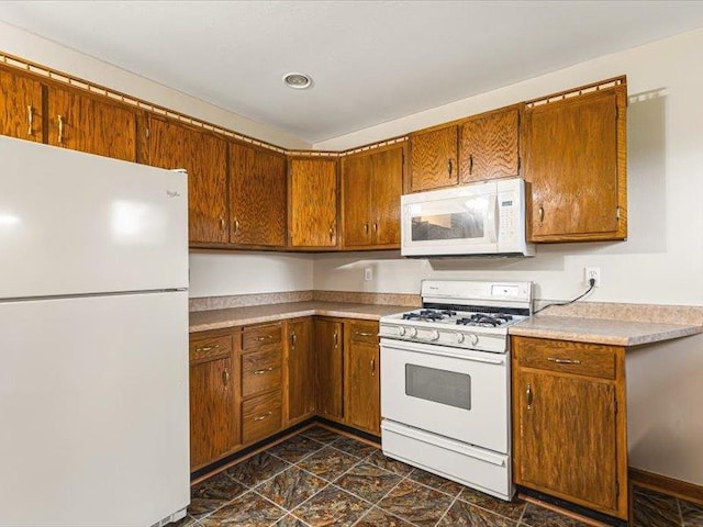 4560 Centerville Rd, Rockford, IL 61102 - kitchen with white appliances, brown cabinetry, light countertops, and dark stone finish floors