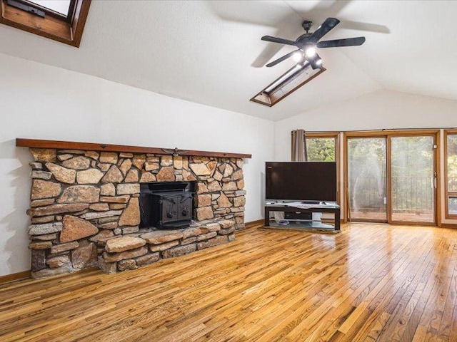4560 Centerville Rd, Rockford, IL 61102 - unfurnished living room with lofted ceiling, ceiling fan, wood-type flooring, a skylight, and a wood stove