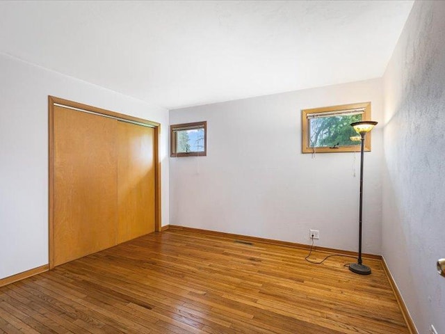 4560 Centerville Rd, Rockford, IL 61102 - unfurnished bedroom with multiple windows, hardwood / wood-style floors, and a closet