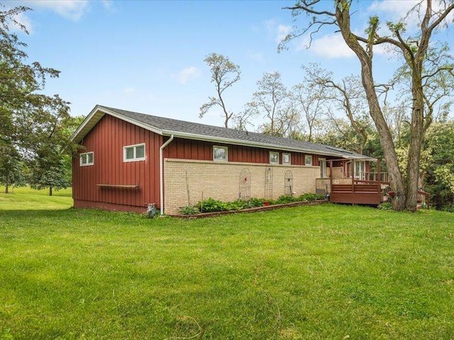 4560 Centerville Rd, Rockford, IL 61102 - rear view of property featuring board and batten siding, a deck, a yard, and brick siding