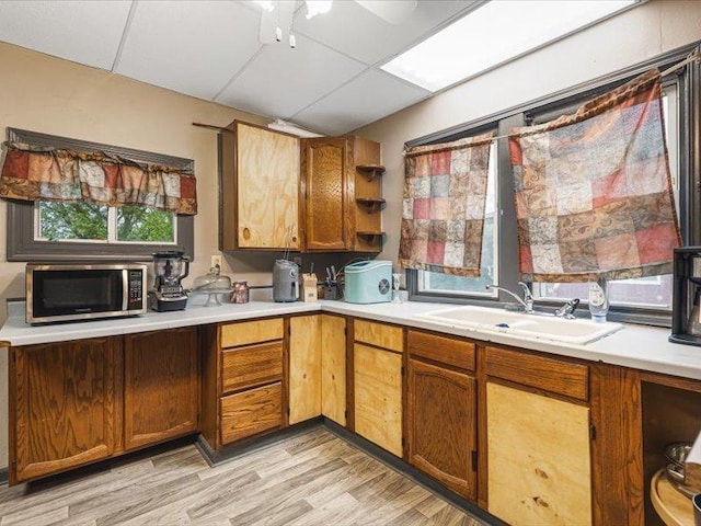 4560 Centerville Rd, Rockford, IL 61102 - kitchen featuring stainless steel microwave, a sink, light countertops, and light wood-style flooring