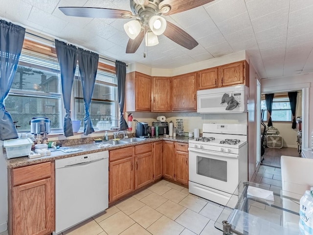 2531 N Lotus Ave, Chicago, IL 60639 - kitchen featuring white appliances, a sink, light tile patterned floors, ceiling fan, and brown cabinetry