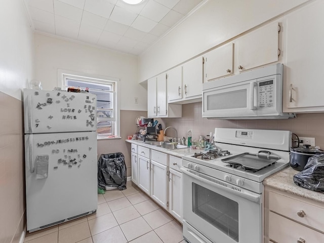 2531 N Lotus Ave, Chicago, IL 60639 - kitchen featuring white appliances, a sink, light countertops, light tile patterned floors, and crown molding