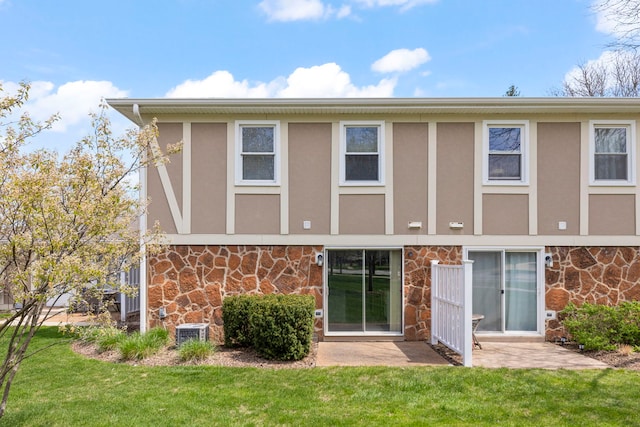 259 Nantucket Hbr Unit 259, Schaumburg, IL 60193 - rear view of house with stone siding, a yard, and stucco siding