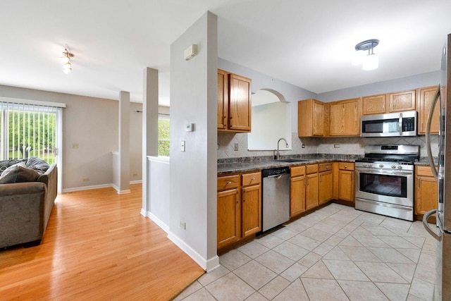 675 Fieldcrest Dr Unit 1A, South Elgin, IL 60177 - kitchen featuring stainless steel appliances, open floor plan, a sink, dark countertops, and decorative backsplash