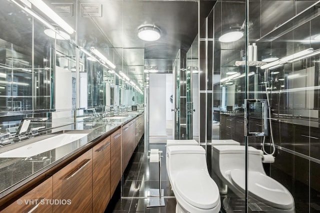 5445 N Sheridan Rd Unit 2715, Chicago, IL 60640 - bathroom featuring toilet, double vanity, a stall shower, and tile patterned floors