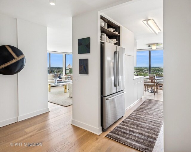 5445 N Sheridan Rd Unit 2715, Chicago, IL 60640 - kitchen with freestanding refrigerator, light wood-style flooring, open shelves, and baseboards