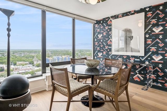 5445 N Sheridan Rd Unit 2715, Chicago, IL 60640 - dining area with wallpapered walls, light wood-type flooring, baseboards, and a city view