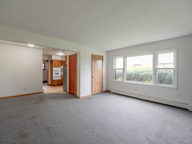 17 King Arthur Ct Unit 7, Northlake, IL 60164 - unfurnished living room featuring baseboard heating, light colored carpet, and baseboards