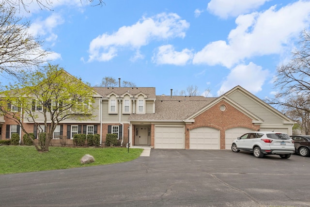 1406 Aldgate Ct Unit D2, Wheeling, IL 60090 - view of front of home with brick siding, a garage, asphalt driveway, a front yard, and roof with shingles
