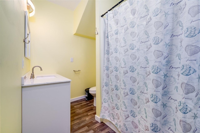 709 S Oak St, Bloomington, IL 61701 - bathroom with wood finished floors, toilet, vanity, curtained shower, and baseboards