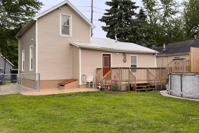 709 S Oak St, Bloomington, IL 61701 - back of house with a wooden deck, metal roof, an outdoor pool, a gate, and a patio