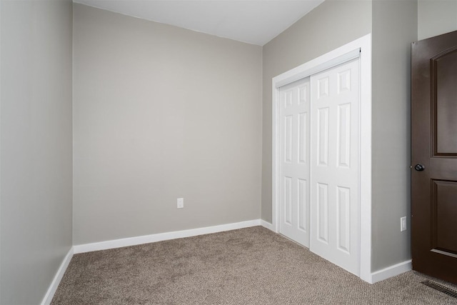 709 S Oak St, Bloomington, IL 61701 - unfurnished bedroom featuring carpet, a closet, and baseboards