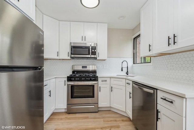 4572 W 131st St Unit 1N, Alsip, IL 60803 - kitchen featuring appliances with stainless steel finishes, a sink, light countertops, white cabinets, and light wood finished floors