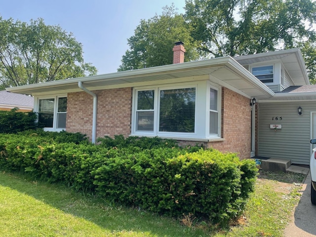 165 Kathleen Dr, Elgin, IL 60123 - view of property exterior featuring brick siding and a chimney
