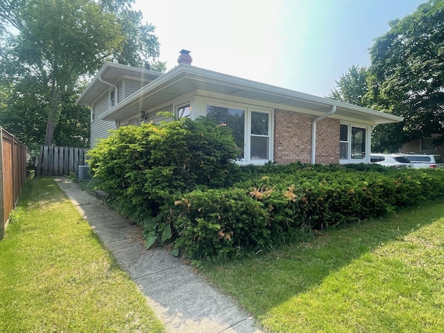 165 Kathleen Dr, Elgin, IL 60123 - view of side of property with a chimney, brick siding, and central AC unit