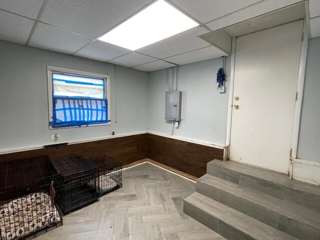 165 Kathleen Dr, Elgin, IL 60123 - below grade area with electric panel, a paneled ceiling, wood walls, and wainscoting