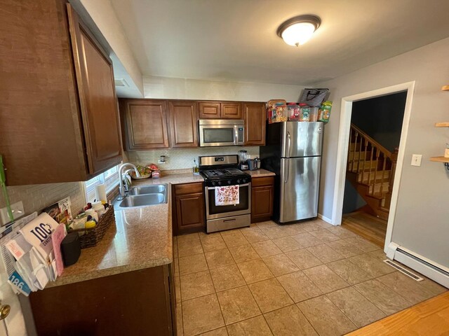 165 Kathleen Dr, Elgin, IL 60123 - kitchen featuring appliances with stainless steel finishes, a sink, light tile patterned floors, backsplash, and a baseboard heating unit