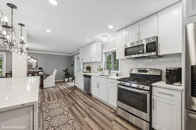 805 S Main St, Wheaton, IL 60189 - kitchen featuring appliances with stainless steel finishes, a sink, crown molding, white cabinets, and recessed lighting