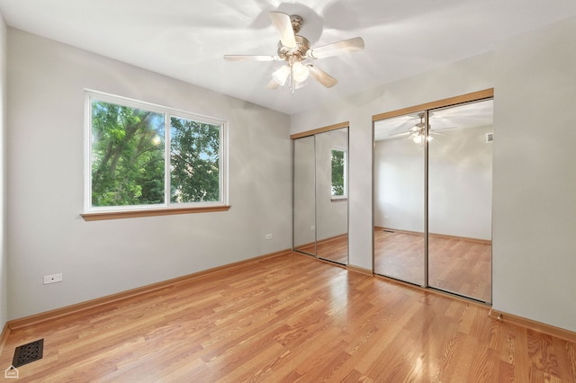 16517 Newbury Ct, Crest Hill, IL 60403 - unfurnished bedroom with two closets, wood finished floors, and a ceiling fan
