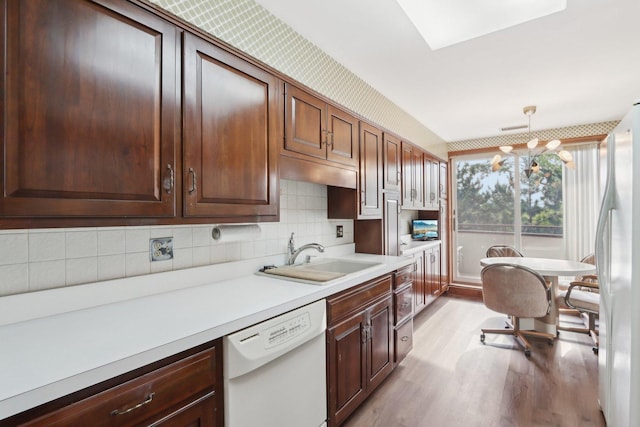 6400 N Cicero Ave Unit 404, Lincolnwood, IL 60712 - kitchen featuring white appliances, a sink, light wood-type flooring, light countertops, and decorative backsplash