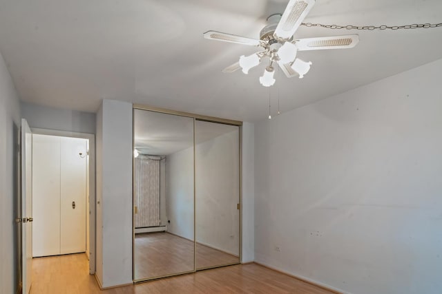1210 N Dale Ave Unit 2I, Arlington Heights, IL 60004 - unfurnished bedroom featuring light wood-style floors, a closet, ceiling fan, baseboards, and a baseboard heating unit