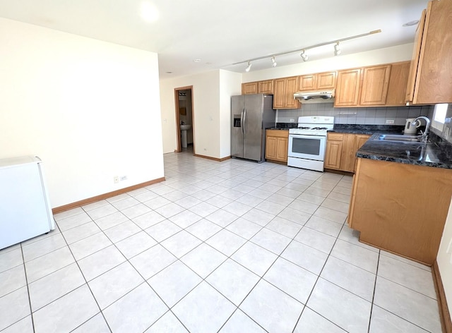 3383 S Archer Ave, Chicago, IL 60608 - kitchen featuring stainless steel fridge, white gas range oven, under cabinet range hood, a sink, and light tile patterned flooring