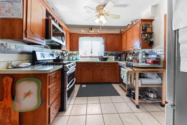 605 E St, Mazon, IL 60444 - kitchen with stainless steel appliances, brown cabinets, a ceiling fan, a sink, and light tile patterned floors