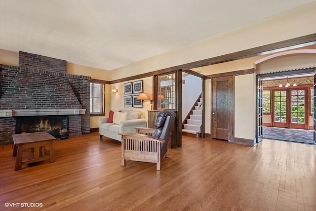 2400 Park Pl, Evanston, IL 60201 - living area with wood finished floors, a brick fireplace, stairway, and french doors