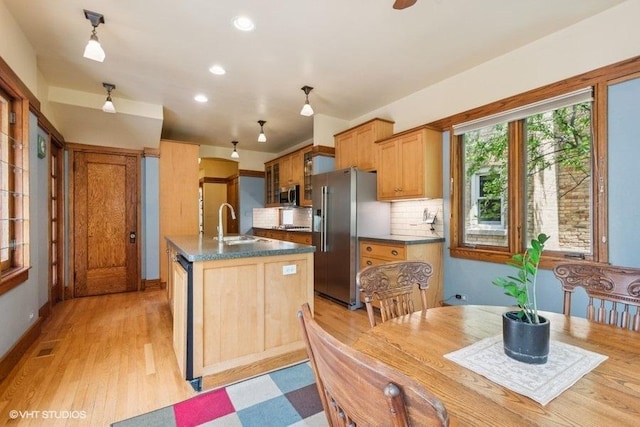 2400 Park Pl, Evanston, IL 60201 - kitchen with appliances with stainless steel finishes, a sink, backsplash, an island with sink, and light wood-style flooring
