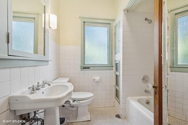 2400 Park Pl, Evanston, IL 60201 - bathroom with tile walls, toilet, tile patterned floors, shower / bathtub combination, and a wainscoted wall
