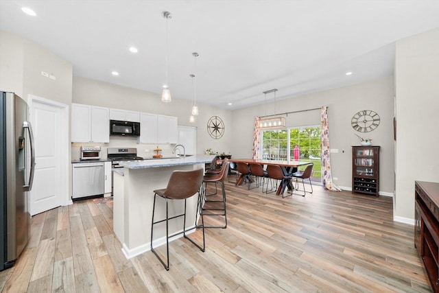 2215 N Woodlawn Park Ave, Mchenry, IL 60051 - kitchen featuring appliances with stainless steel finishes, light wood-style flooring, white cabinets, recessed lighting, and a sink