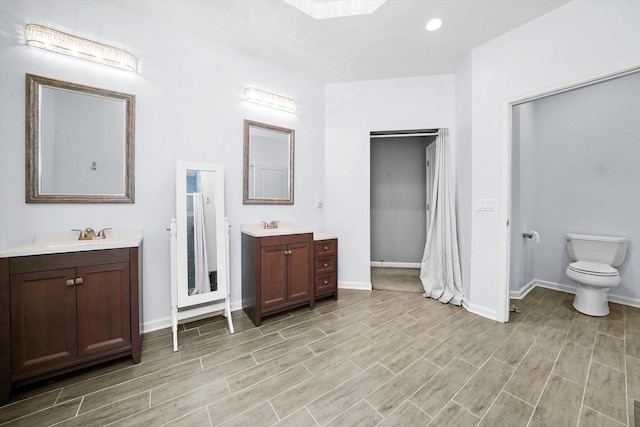 2215 N Woodlawn Park Ave, Mchenry, IL 60051 - bathroom with wood finished floors, two vanities, baseboards, toilet, and recessed lighting