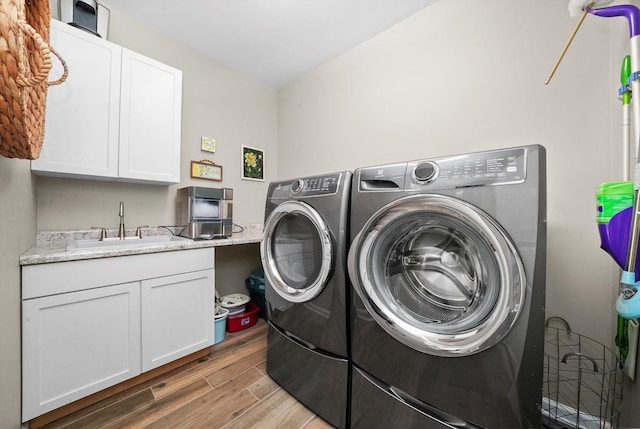 2215 N Woodlawn Park Ave, Mchenry, IL 60051 - laundry area featuring separate washer and dryer, wood finished floors, and cabinet space