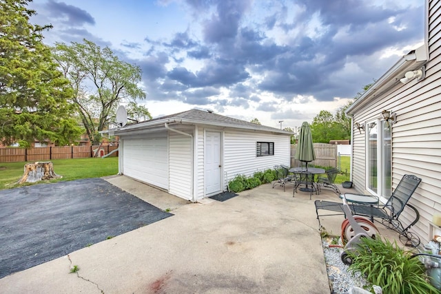 11030 S Nagle Ave, Worth, IL 60482 - view of patio with an outbuilding, outdoor dining space, a detached garage, and driveway